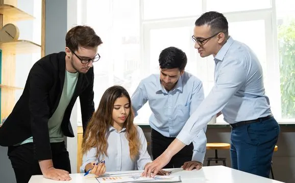 A mentor walking three colleagues through a plan