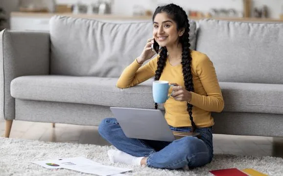 A woman working on a laptop from her living room