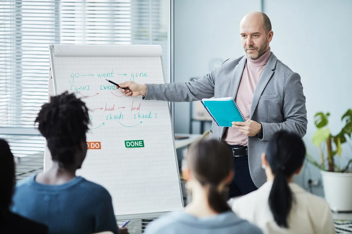 An instructor at a whiteboard teaching a small class